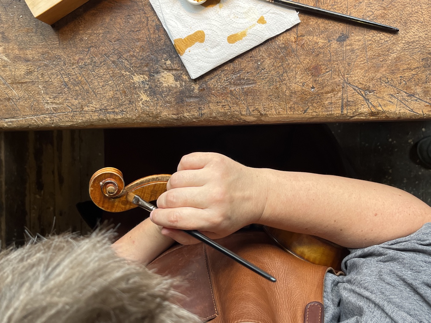 Retouche minutieuse de vernis sur la volute d'un violon